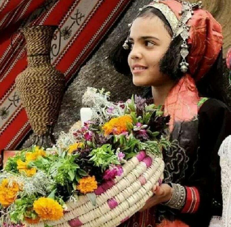 Une petite fille de Ta'izz vendant des fleurs aux touristes en tenue traditionnelle